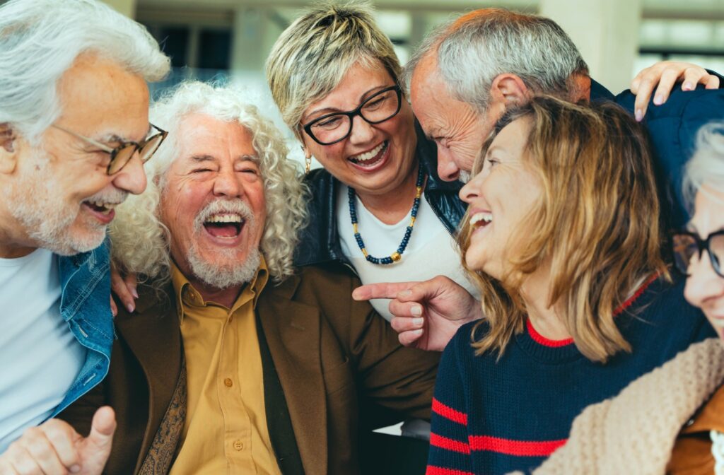 A happy group of seniors laugh together while having fun in their retirement years.